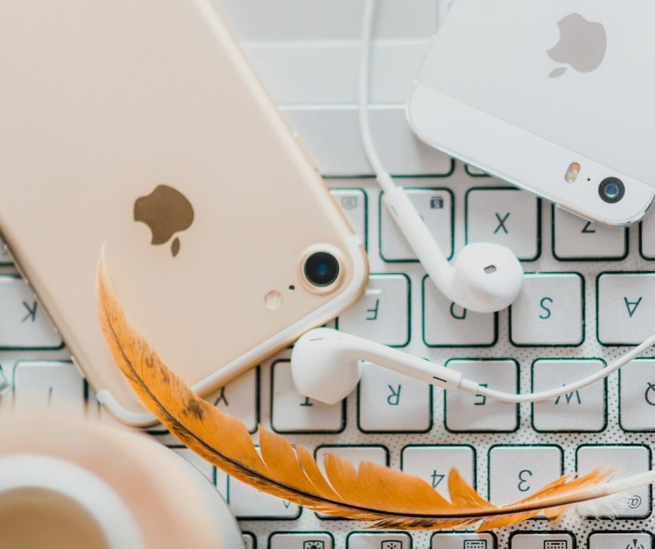 apple music gold iPhone 7 beside white Apple EarPods and silver iPhone 5s